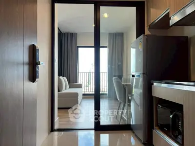 Modern apartment with open kitchen and cozy living room leading to balcony.