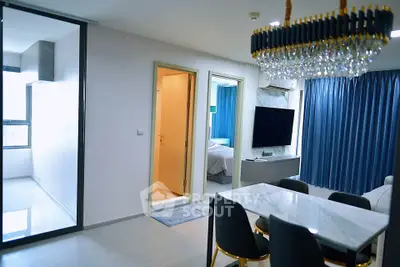 Luxurious modern apartment interior with elegant dining area and spacious living room featuring a stunning chandelier.