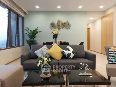 Stylish living room with modern decor and large windows offering city views.
