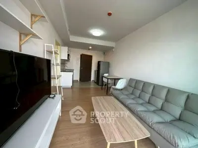 Modern living room with sleek furniture and open kitchen layout.