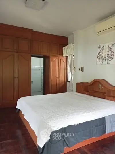 Spacious bedroom with wooden furniture and built-in wardrobe