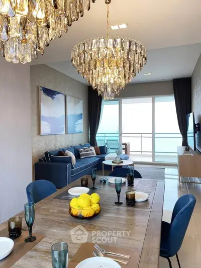 Luxurious dining and living area with elegant chandeliers and ocean view balcony.