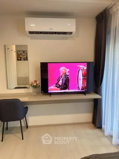 Modern living room with TV and air conditioning, featuring stylish decor and comfortable seating.