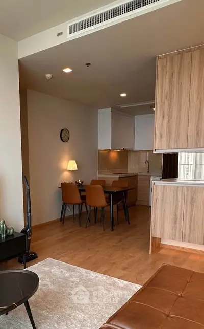 Modern open-plan living and dining area with stylish wooden furniture and cozy lighting.