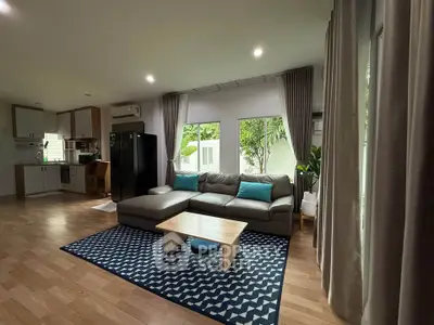 Spacious living room with modern decor and large windows in a stylish home.