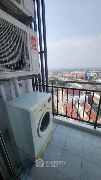 High-rise balcony with washing machine and stunning city view, perfect for urban living.