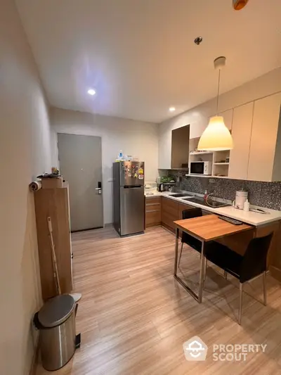 Modern kitchen with sleek cabinets and dining area in cozy apartment