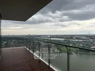 Stunning high-rise balcony with panoramic river and city views, perfect for relaxation and entertainment.