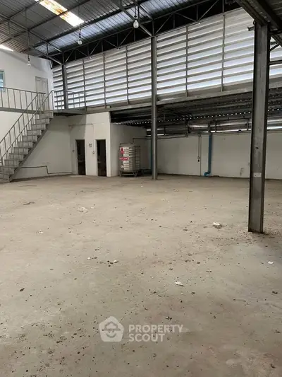 Spacious industrial warehouse with high ceilings and mezzanine level, ideal for storage or manufacturing.