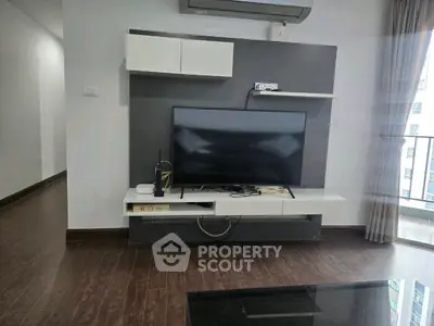 Modern living room with sleek TV setup and balcony view