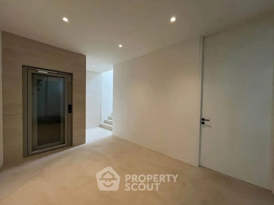 Modern interior with elevator and minimalist design, featuring neutral tones and sleek finishes.