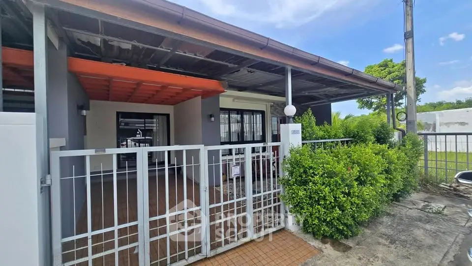 Charming single-story home with gated entrance and lush greenery, perfect for family living.