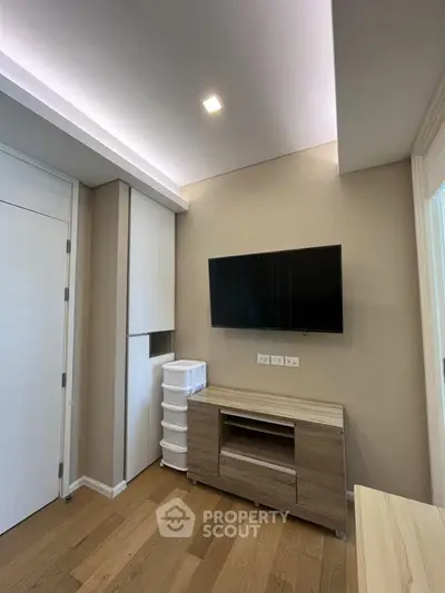 Modern living room with wall-mounted TV and stylish wooden furniture