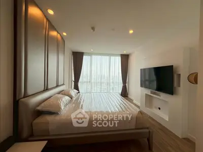Luxurious bedroom with city view, modern decor, and large TV