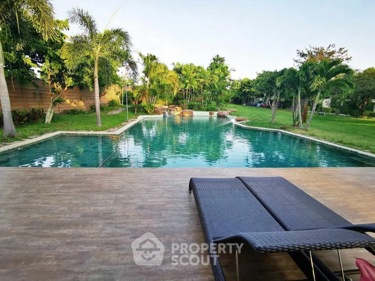 Luxurious poolside view with lush greenery and modern lounge chairs