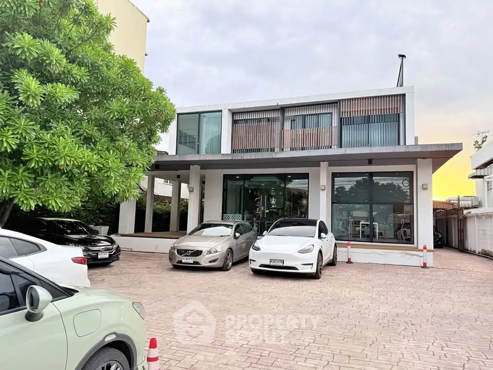 Modern commercial building with parking area and sleek glass facade