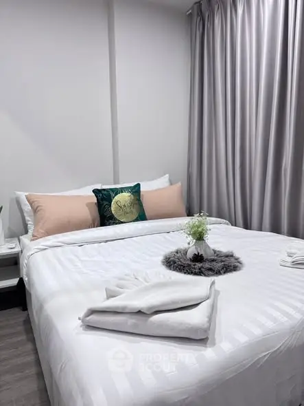 Cozy bedroom with elegant decor and plush bedding in modern apartment.