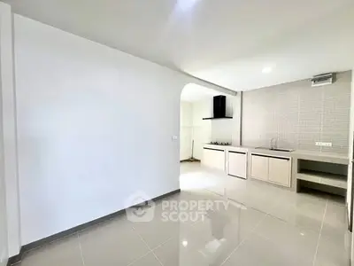 Modern kitchen with sleek design and open layout, featuring glossy tiles and built-in appliances.