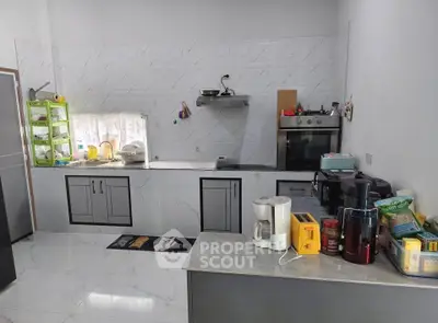 Modern kitchen with sleek cabinetry, marble countertops, and built-in oven, perfect for culinary enthusiasts.