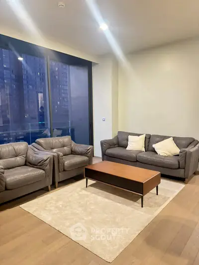 Modern living room with leather sofas and city view, perfect for urban living.