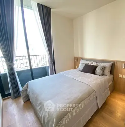 Modern bedroom with large window and balcony access, featuring elegant curtains and cozy bedding.