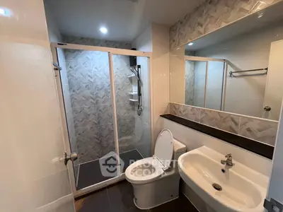Modern bathroom with sleek shower and elegant fixtures in a contemporary apartment.