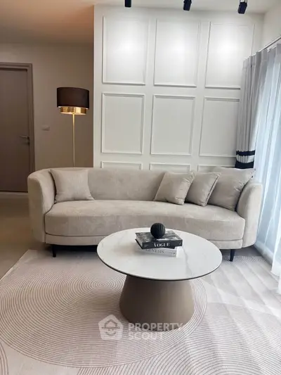 Elegant living room with modern beige sofa and stylish round coffee table, perfect for cozy gatherings.
