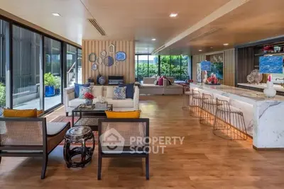 Luxurious open-plan living room with modern decor and spacious seating area, featuring large windows and elegant wooden flooring.