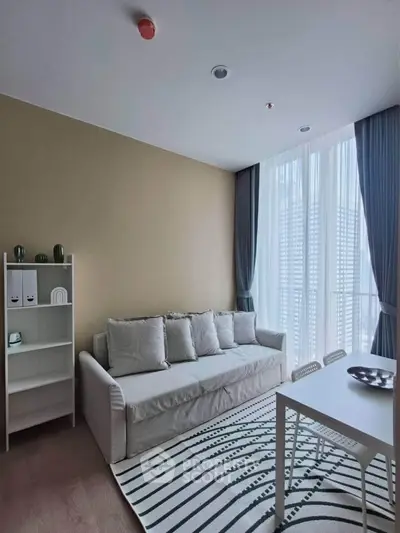 Modern living room with cozy sofa, stylish decor, and large window for natural light.