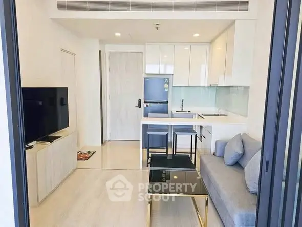 Modern open-layout living room with sleek kitchen and stylish furniture in a contemporary apartment.