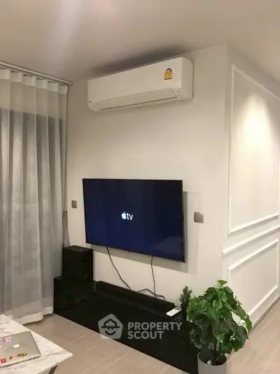 Modern living room with wall-mounted TV and air conditioning unit.