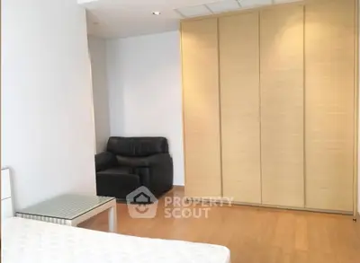 Spacious bedroom with modern wardrobe and cozy seating area.