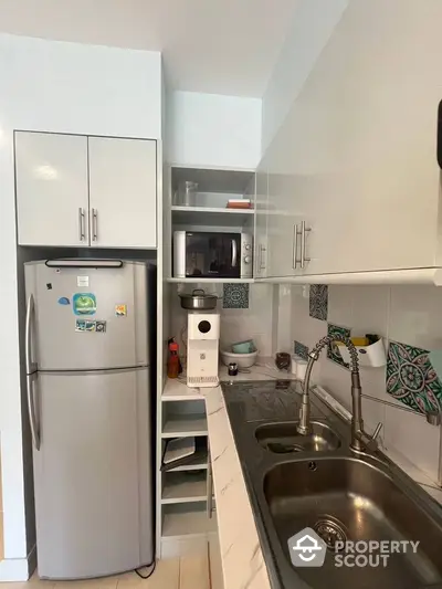 Compact kitchen with modern appliances and stylish backsplash tiles