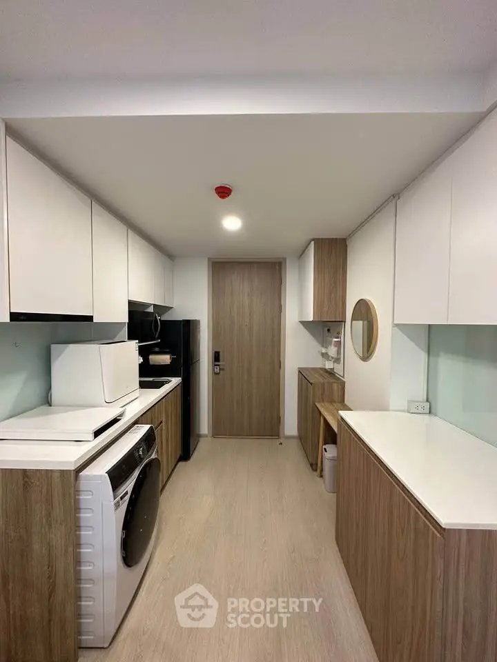 Modern kitchen with sleek cabinetry and integrated appliances in a compact layout.