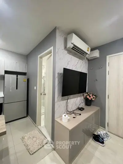 Modern apartment interior with sleek kitchen and cozy living area featuring air conditioning and stylish decor.