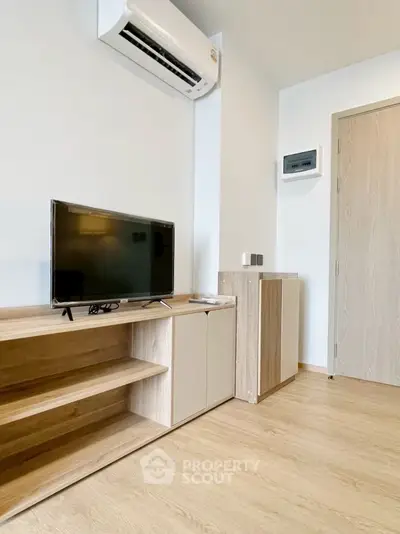 Modern living room with sleek TV setup and air conditioning unit