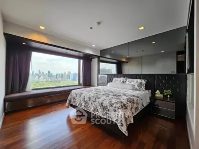 Luxurious bedroom with stunning city view and elegant decor, featuring a large window and hardwood floors.