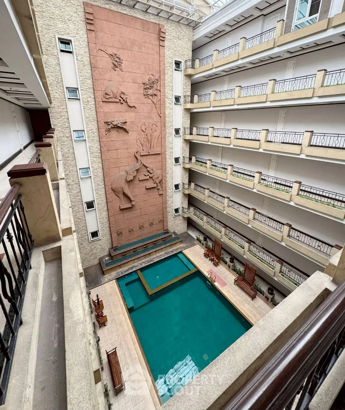 Stunning indoor pool area with elegant architectural design and artistic wall reliefs in a luxurious building.