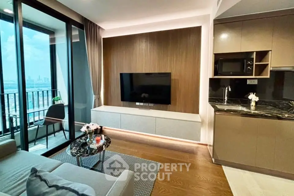 Modern living room with balcony and city view, featuring sleek furniture and stylish decor.