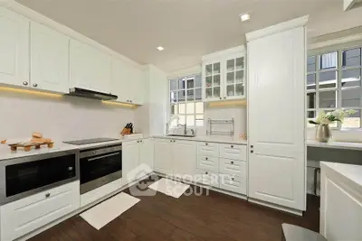 Elegant kitchen with white cabinetry and modern appliances in a spacious layout.