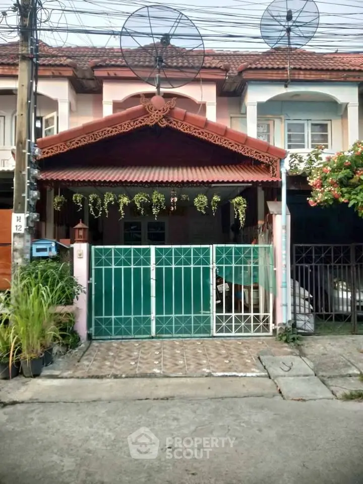 Charming townhouse with decorative facade and gated entrance in a cozy neighborhood.