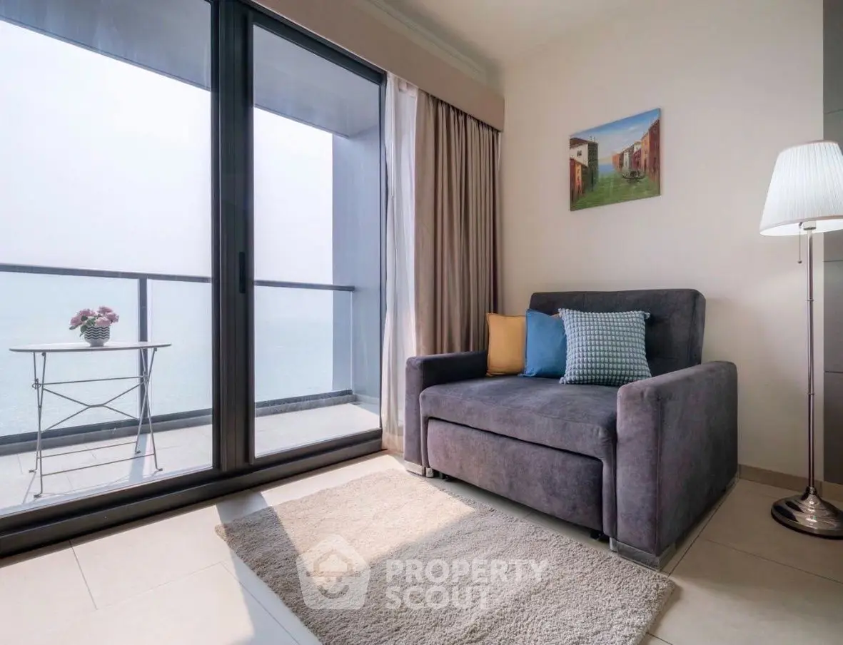 Cozy living room with ocean view, modern decor, and balcony access.