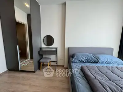 Modern bedroom with stylish decor and ample natural light, featuring a cozy bed and sleek furniture.