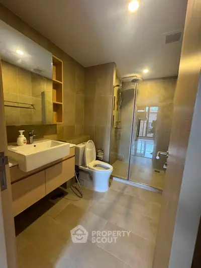 Modern bathroom with glass shower and sleek fixtures in a contemporary home.