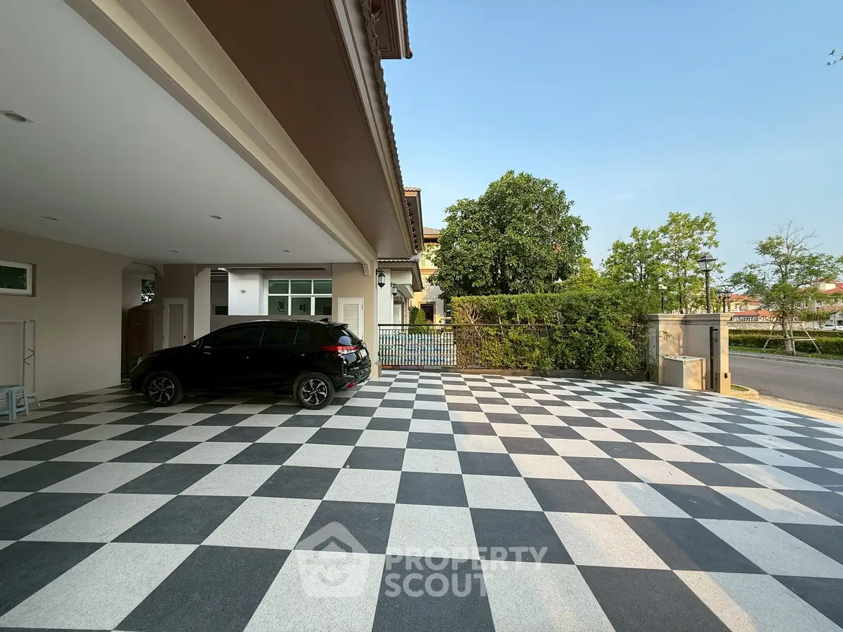 Spacious driveway with checkered tiles and modern architecture, perfect for multiple vehicles.