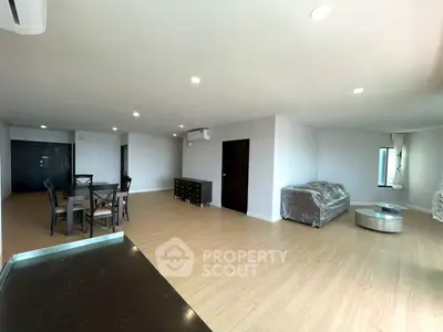 Spacious modern living room with dining area and stylish furniture in open layout apartment.
