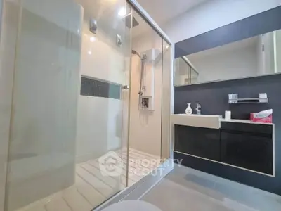 Modern bathroom with sleek shower and stylish vanity in contemporary home.