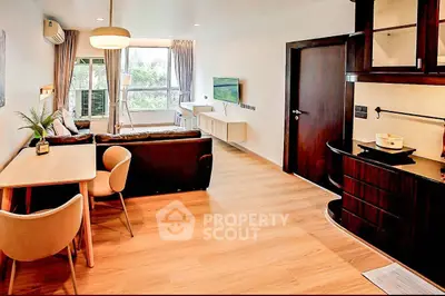 Modern living room with stylish furniture and open layout, featuring a cozy dining area and large window view.