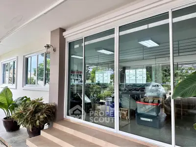 Modern building entrance with large glass doors and potted plants, showcasing a sleek and inviting exterior.