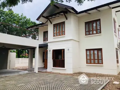 Charming two-story house with spacious driveway and lush greenery